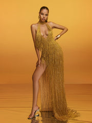 Robe longue dorée à col halter, franges et découpes.