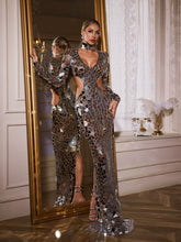 Robe longue argentée ornée de découpes et d'acrylique.